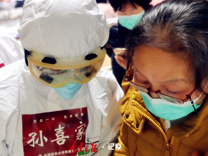 透过满是水雾的护目镜,医生孙喜佳给患者查看检查结果.